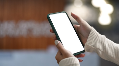 Manos sujetando un teléfono móvil con la pantalla en blanco